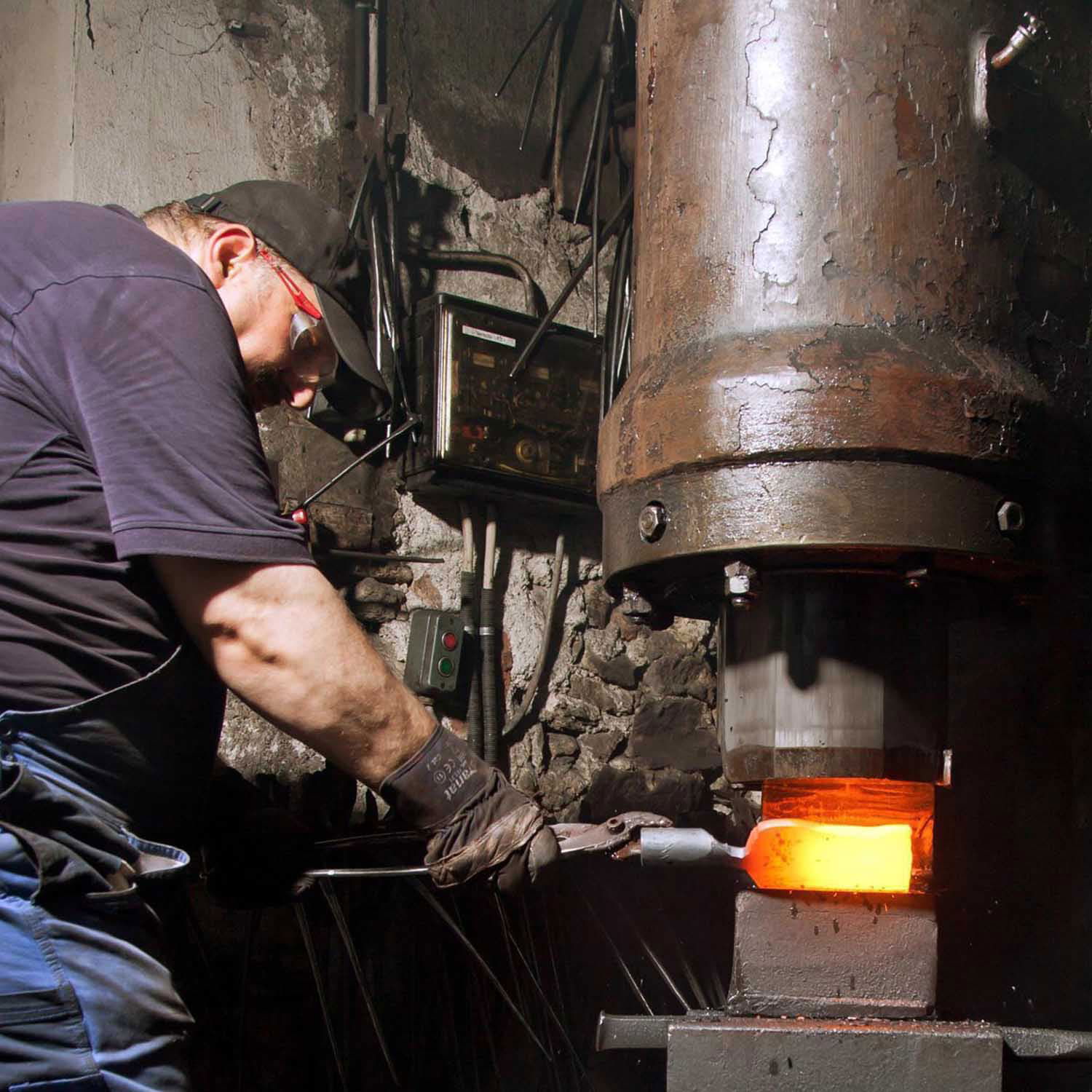 Smed former glødende metal på maskinhammer