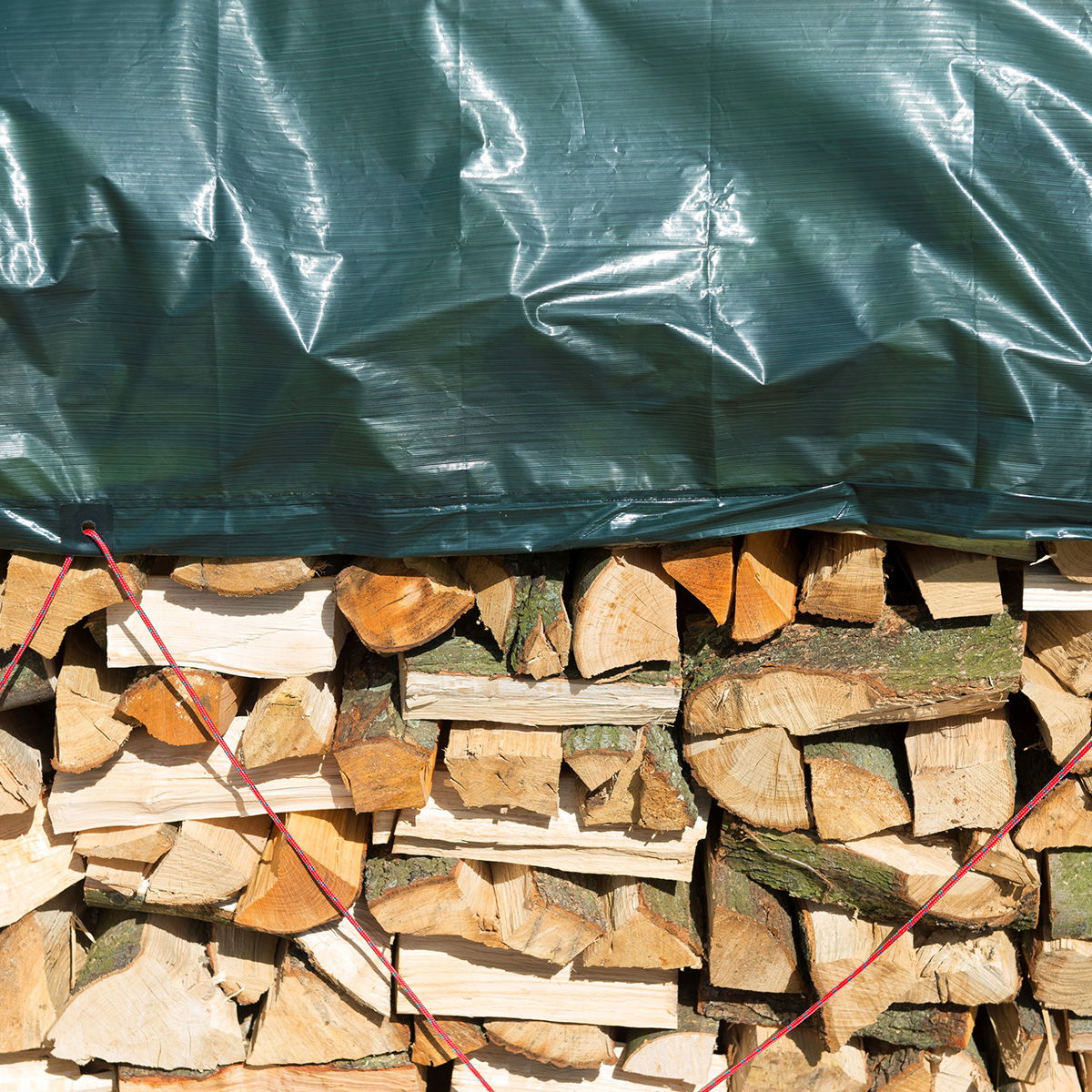 Brændestak dækket med grøn presenning