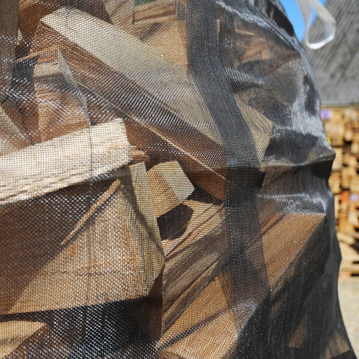 Tørt brændetræ i sort netpose